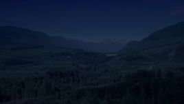 4K day for night color corrected aerial stock footage of a forest and a narrow road through evergreen trees in King County, Washington Aerial Stock Footage | AX48_057_DFN