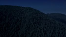 4K day for night color corrected aerial stock footage of evergreen trees covering a mountain ridge in the Cascade Range, Washington Aerial Stock Footage | AX48_062_DFN