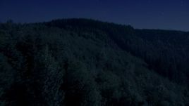 4K day for night color corrected aerial stock footage of flying over an evergreen forest and approach a mountain ridge in the Cascade Range, Washington Aerial Stock Footage | AX48_083_DFN