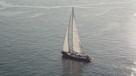 5K aerial stock footage track a sailboat on Elliott Bay, reflecting the sunlight, Seattle, Washington Aerial Stock Footage | AX49_080