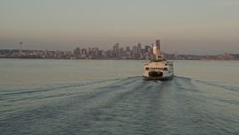 5K aerial stock footage fly low by a ferry sailing Elliott Bay to reveal Downtown Seattle skyline, Washington, sunset Aerial Stock Footage | AX50_016