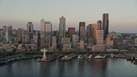 5K aerial stock footage orbit Downtown Seattle skyscrapers, Alaskan Way Viaduct, and Central Waterfront piers in Washington, sunset Aerial Stock Footage | AX50_023