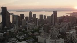 5K aerial stock footage of passing skyscrapers in Downtown Seattle, Washington, and reveal the setting sun over Elliott Bay Aerial Stock Footage | AX50_027