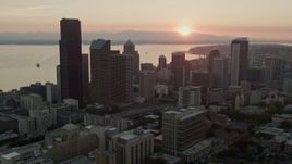 5K aerial stock footage of passing skyscrapers in Downtown Seattle, Washington, and reveal the setting sun over Elliott Bay Aerial Stock Footage | AX50_027E