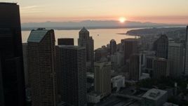 5K aerial stock footage of skyscrapers toward the setting sun over Elliott Bay, Downtown Seattle, Washington, sunset Aerial Stock Footage | AX50_030