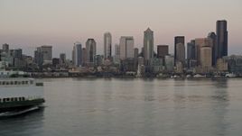 5K aerial stock footage track a ferry sailing Elliott Bay and reveal the Downtown Seattle skyline in Washington, sunset Aerial Stock Footage | AX50_044