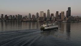 5K aerial stock footage track a ferry sailing Elliott Bay toward the Seattle Waterfront and Downtown Seattle skyline in Washington, sunset Aerial Stock Footage | AX50_047