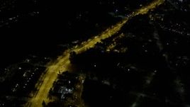 5K aerial stock footage of bird's eye of a brightly-lit road through dark suburban neighborhoods, Rainier Beach, Seattle, Washington, night Aerial Stock Footage | AX51_005