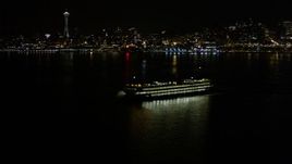 5K aerial stock footage orbit ferry sailing Elliott Bay at night, Downtown Seattle skyline in background, Washington Aerial Stock Footage | AX51_010