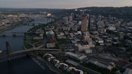5K aerial stock footage of flying by city bridges across the Willamette River, Downtown Portland, Oregon, sunset Aerial Stock Footage | AX54_030