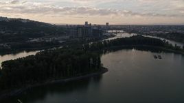 5K aerial stock footage of flying by Ross Island, South Waterfront, Downtown Portland, Oregon in the distance, sunset Aerial Stock Footage | AX54_053