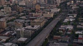 5K aerial stock footage track cars on Interstate 405, tilt to reveal skyscrapers in Downtown Portland, Oregon, sunset Aerial Stock Footage | AX54_085