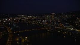 5K aerial stock footage pan from Memorial Coliseum and the Broadway Bridge to reveal Downtown Portland, Oregon, night Aerial Stock Footage | AX55_024