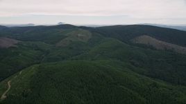 5K aerial stock footage fly over forest to approach a hillside clear cut area in Washington County, Oregon Aerial Stock Footage | AX56_032