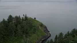 5K aerial stock footage of reverse view of steep cliffs and the Cape Disappointment Light, Washington Aerial Stock Footage | AX56_097