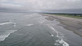 5K aerial stock footage fly over waves rolling in near a beachgoer on the sand in Seaview, Washington Aerial Stock Footage | AX56_132