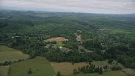 5K aerial stock footage fly over farm fields to approach a small farm and evergreen forest in Satsop, Washington Aerial Stock Footage | AX57_018