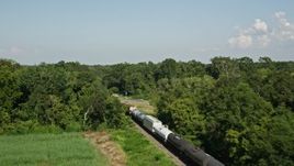 5K aerial stock footage track a train traveling past sugar cane fields and over a country road in Vacherie, Louisiana Aerial Stock Footage | AX60_064