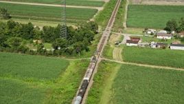 5K aerial stock footage of tracking a train speeding past rural homes and sugar cane fields, Edgard, Louisiana Aerial Stock Footage | AX60_070