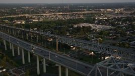 5K aerial stock footage fly over the convention center to track cars on Crescent City Connection Bridge at sunset, New Orleans, Louisiana Aerial Stock Footage | AX61_020
