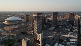 5K aerial stock footage flyby downtown and Plaza Tower to approach Superdome and New Orleans Arena at sunset, New Orleans, Louisiana Aerial Stock Footage | AX61_026E