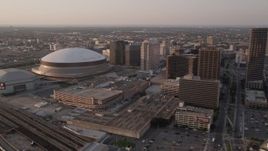 5K aerial stock footage flyby Plaza Tower to approach Superdome and New Orleans Arena at sunset, New Orleans, Louisiana Aerial Stock Footage | AX61_027