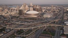 5K aerial stock footage reverse view of Superdome and Downtown New Orleans skyscrapers at sunset, Louisiana Aerial Stock Footage | AX61_029