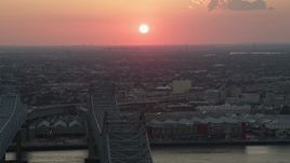 5K aerial stock footage of the setting sun seen from Crescent City Connection Bridge at sunset, New Orleans, Louisiana Aerial Stock Footage | AX61_069