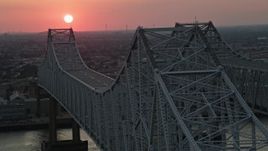 5K aerial stock footage of light traffic on the Crescent City Connection Bridge and setting sun in the background, New Orleans, Louisiana Aerial Stock Footage | AX61_070