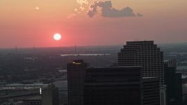 5K aerial stock footage of the setting sun behind Plaza Tower and Downtown New Orleans, Louisiana Aerial Stock Footage | AX61_071
