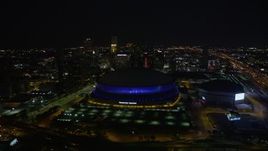 5K aerial stock footage fly over the Superdome at night and approach skyscrapers in Downtown New Orleans, Louisiana Aerial Stock Footage | AX62_006E
