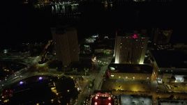 5K aerial stock footage fly over Harrah's Casino to approach World Trade Center and Hilton Riverside at night, Downtown New Orleans, Louisiana Aerial Stock Footage | AX62_009