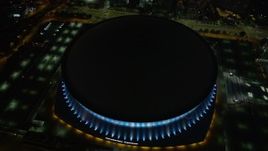 5K aerial stock footage orbit the Superdome at night as lights change color, Downtown New Orleans, Louisiana Aerial Stock Footage | AX62_012