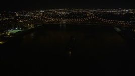 5K aerial  video of cargo ship sailing under Crescent City Connection Bridge at night, New Orleans, Louisiana Aerial Stock Footage | AX62_015