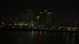 5K aerial stock footage of low altitude view of riverfront skyscrapers in Downtown New Orleans at night, Louisiana Aerial Stock Footage | AX62_031