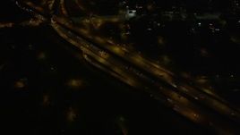 5K aerial stock footage of reverse and bird's eye view of freeway interchange at night, New Orleans, Louisiana Aerial Stock Footage | AX62_049