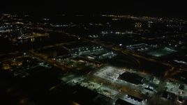 5K aerial stock footage reverse view of a strip mall by the Danziger and I-10 High Rise Bridges at night, New Orleans, Louisiana Aerial Stock Footage | AX62_050