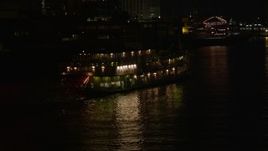 5K aerial stock footage of tracking Natchez Steamboat on Mississippi River at night, French Quarter, New Orleans, Louisiana Aerial Stock Footage | AX63_007E
