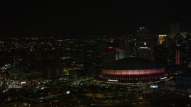 5K aerial stock footage of lighting change at the Superdome near Downtown New Orleans skyscrapers at night, Louisiana Aerial Stock Footage | AX63_022