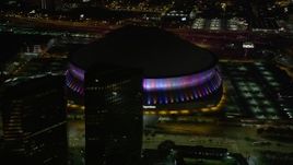 5K aerial stock footage orbit the Mercedes-Benz Superdome at night and the lights change colors, Downtown New Orleans, Louisiana Aerial Stock Footage | AX63_025