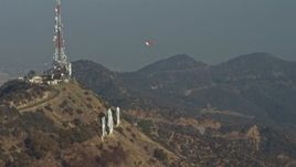 5K aerial stock footage of emergency helicopter flying around Hollywood Sign and landing by the radio towers, Los Angeles, California Aerial Stock Footage | AX64_0014E