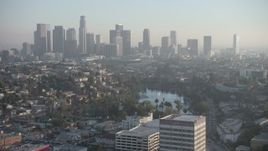 5K aerial stock footage of an approach to Echo Park and hazy Downtown Los Angeles skyline, California Aerial Stock Footage | AX64_0078