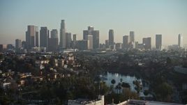 5K aerial stock footage of an approach to Echo Park and hazy Downtown Los Angeles skyline, California Aerial Stock Footage | AX64_0078E