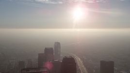 5K aerial stock footage of sun over haze and skyscrapers in Downtown Los Angeles, California Aerial Stock Footage | AX64_0098
