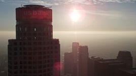 5K aerial stock footage of sun over haze and Downtown Los Angeles skyscrapers, California Aerial Stock Footage | AX64_0098E