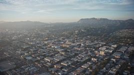 5K aerial stock footage fly over neighborhoods in East Hollywood and approach Hollywood Sign, Los Angeles, California, Sunset Aerial Stock Footage | AX64_0112E