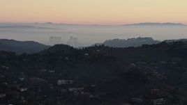 5K aerial stock footage of Century City behind hilltop mansions in Hollywood Hills, California, twilight Aerial Stock Footage | AX64_0156E