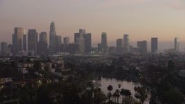 5K aerial stock footage of Downtown Los Angeles in haze and Echo Lake at twilight, California Aerial Stock Footage | AX64_0182