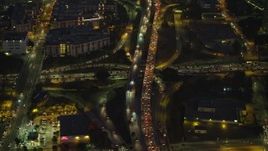 5K aerial stock footage of reverse view of heavy traffic on 101 and 110 freeways in Downtown Los Angeles, California, Night Aerial Stock Footage | AX64_0253