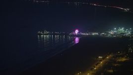 5K aerial stock footage of approaching iconic Santa Monica Pier and the Pacific Wheel at night, Los Angeles, California Aerial Stock Footage | AX64_0298